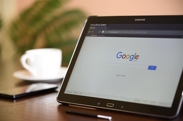 Folding tablet standing on table with Google search engine displayed