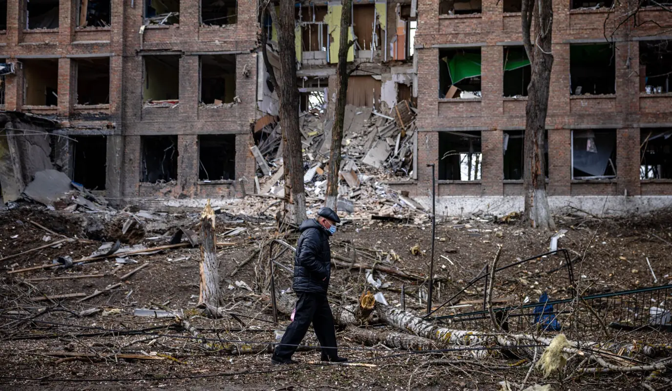 A man walks in front of a destroyed building after a missile attack in the town of Vasylkiv