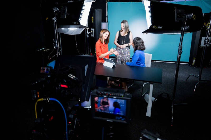 Three colleagues talking in a video production studio