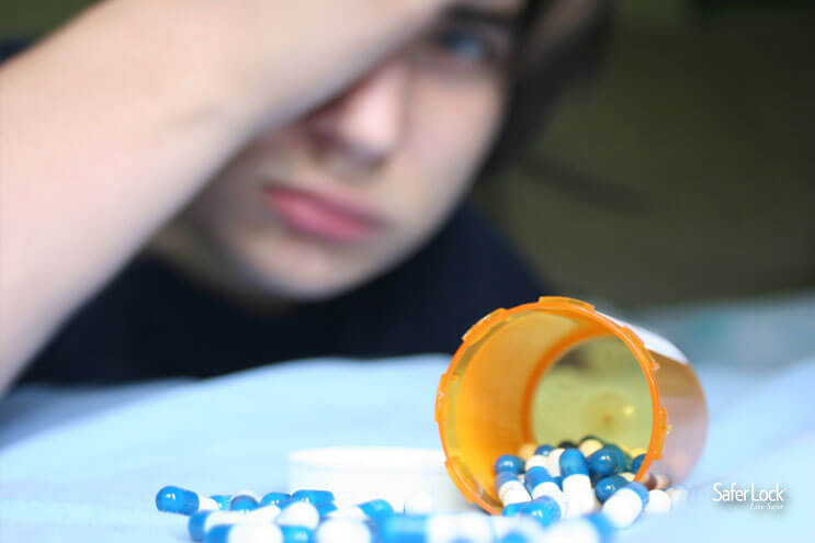 An open medication bottle with pills spilling out and a sullen boy in the background.