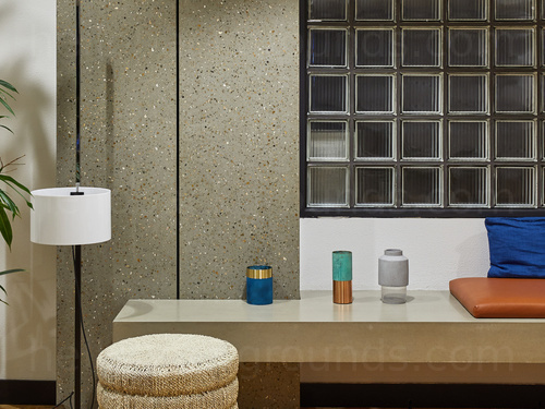 Public bathroom with various candles and padded seating on grey stone bench  Zoom background