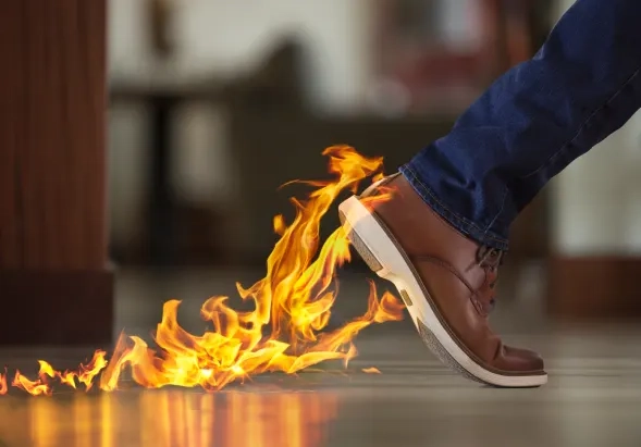 man’s foot leaving trail of flames on floor