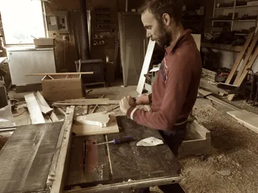 A photograph of Ty in his workshop working on a piece of wood