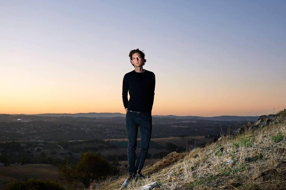 Matthias schack-arnott stands on the side of a hill looking at camera
