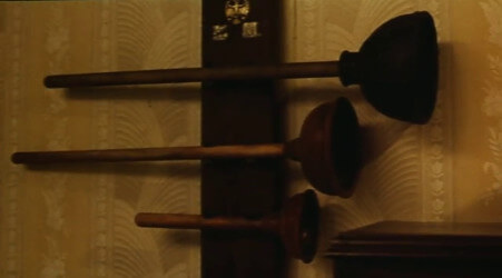 A shot from the Super Mario Bros. movie, showing a series of plungers hung on a wall as trophies