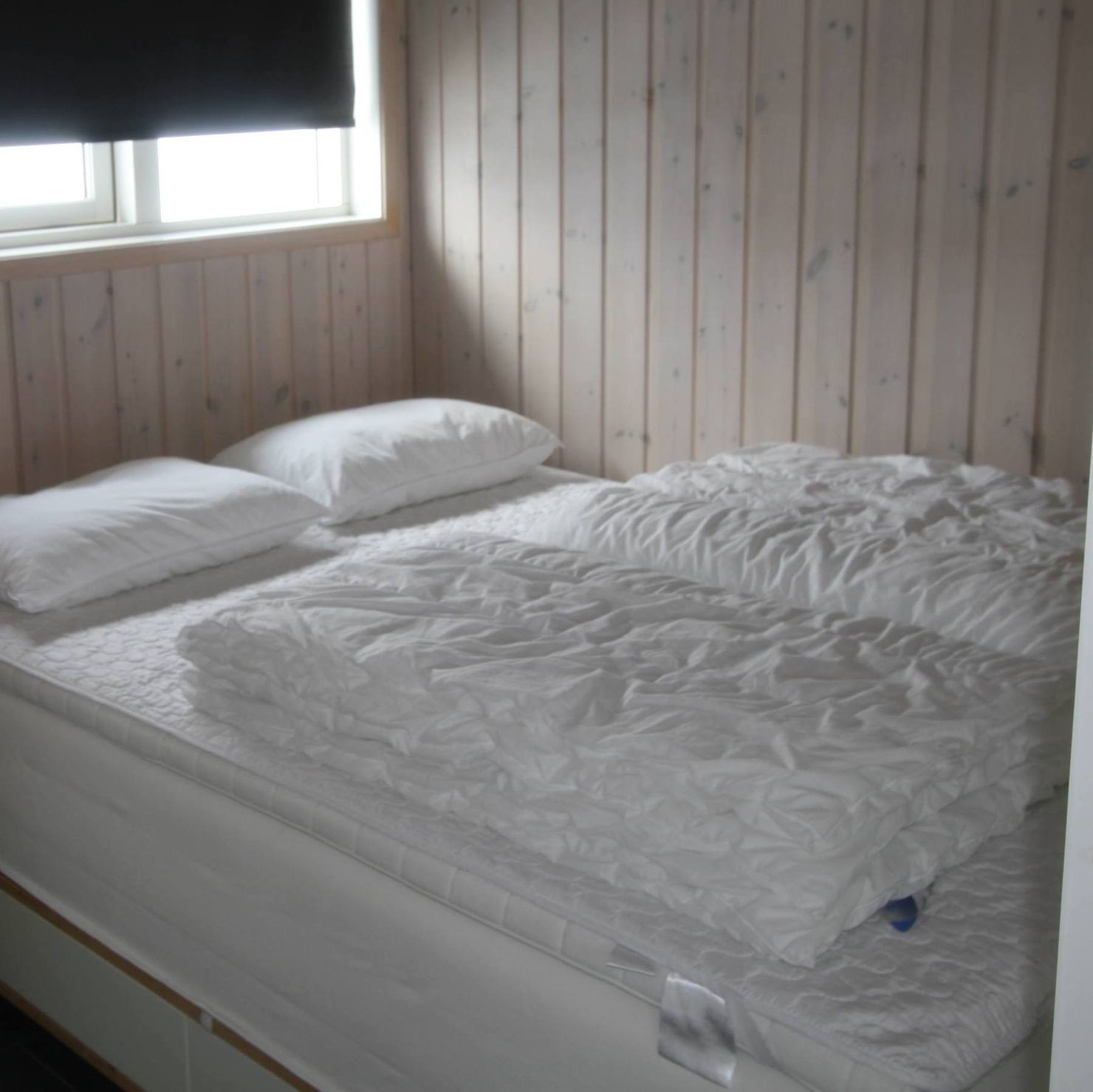 Schlafzimmer mit einem Doppelbett, Kommode und Verdunkelungsvorhängen