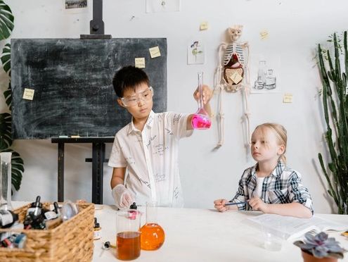 Two children doing science experiments in a science classroom