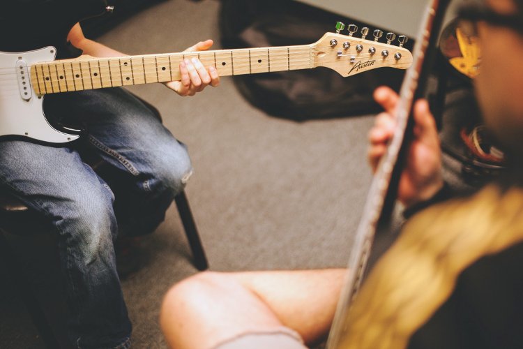 Guitar lesson with student and teacher