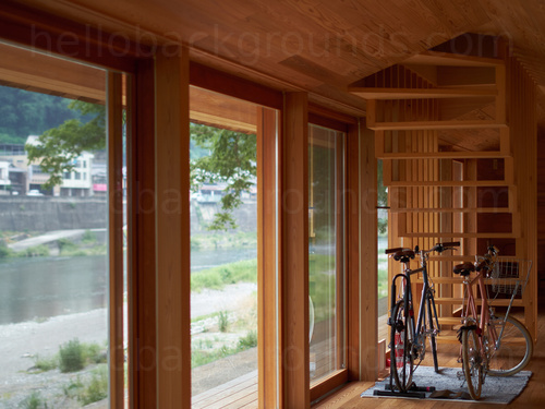 Contemporary wooden cabin design hallway featuring two bikes and sliding doors opening out onto river view Zoom background