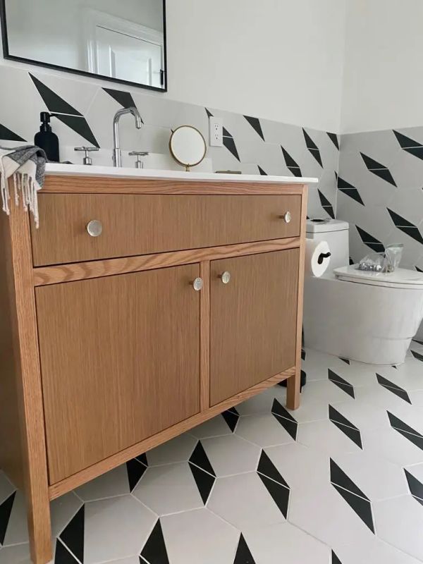 Remodeled Bathroom with striped tile flooring and walls along with a brown wood finish