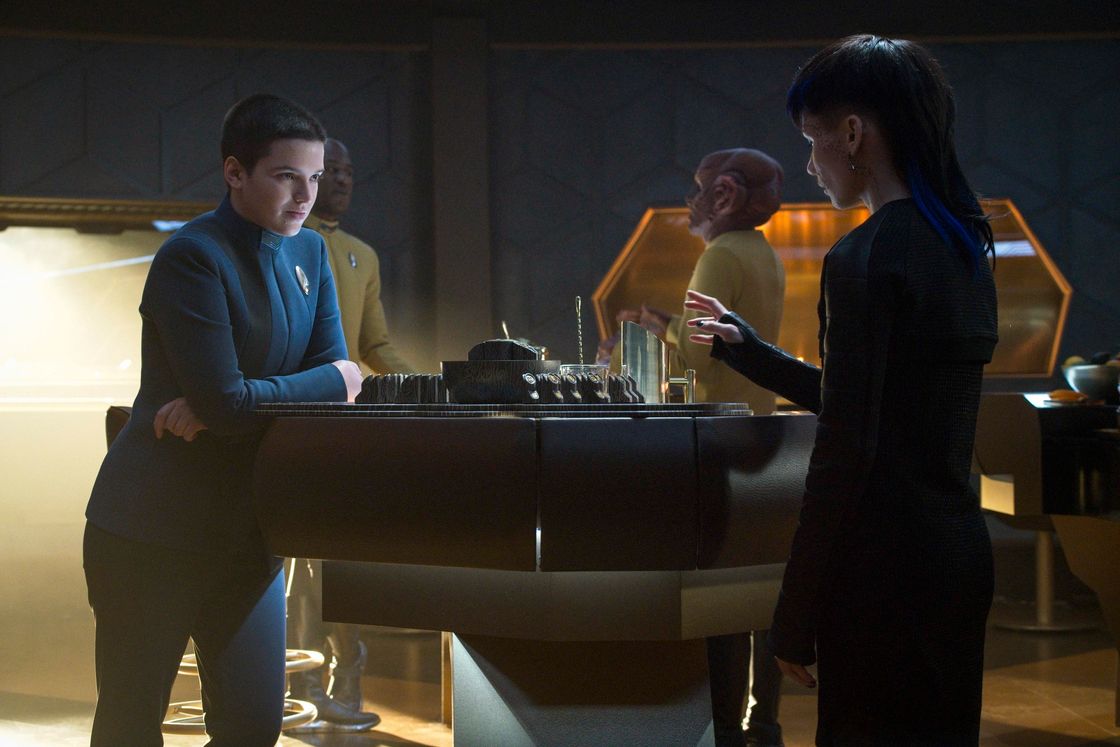 Scene from Star Trek: Discovery. The non-binary human Adira Tal and the trans man Gray Tal play some sort of sci-fi board game in a dimly lit room aboard a starship.