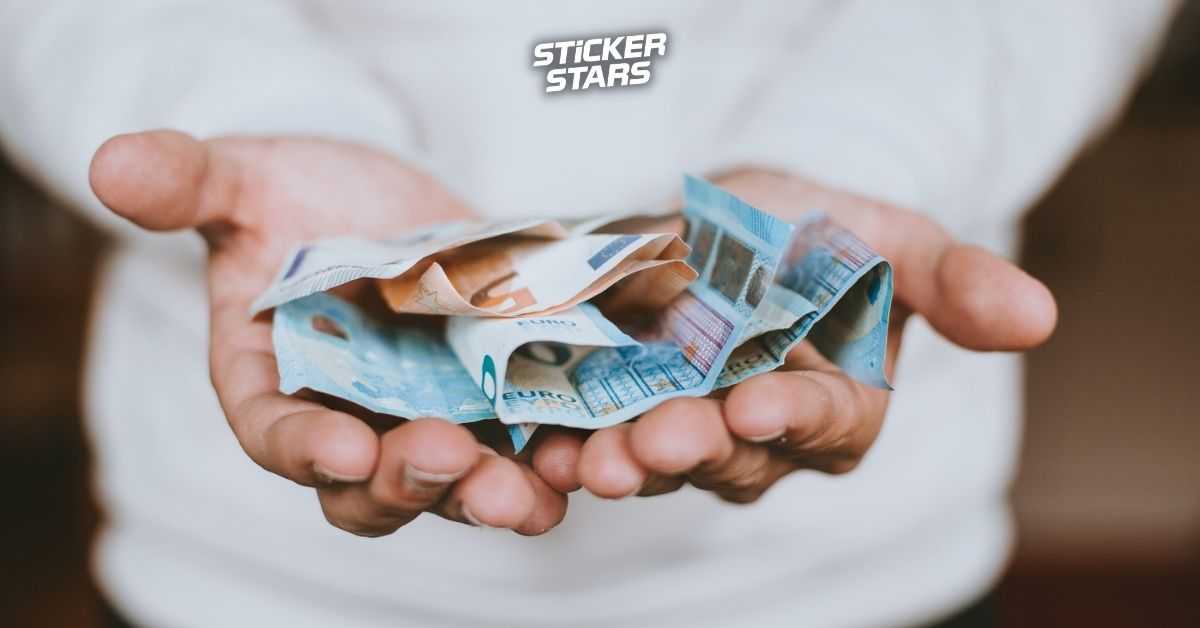 Eine Person hält einige Geldscheine in den Händen in Richtung Kamera