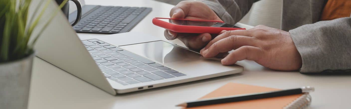 Laptop mit Smartphone Kunde vor Laptop ruft mit seinem Smartphone an