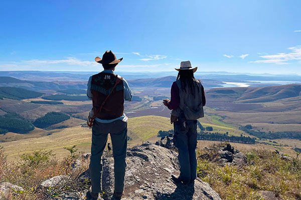 Two cowboys looking out over a beautiful valley.