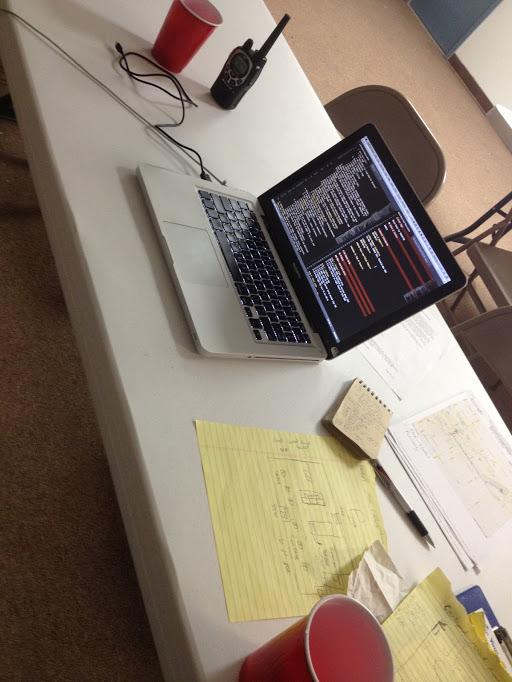 Hesap on a table with scattered papers and a radio, with markdown on the screen.