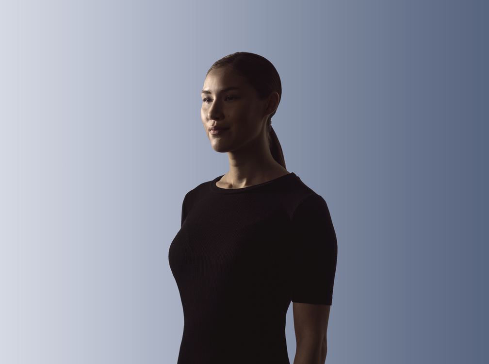 A woman in a black shirt facing forward optimistically