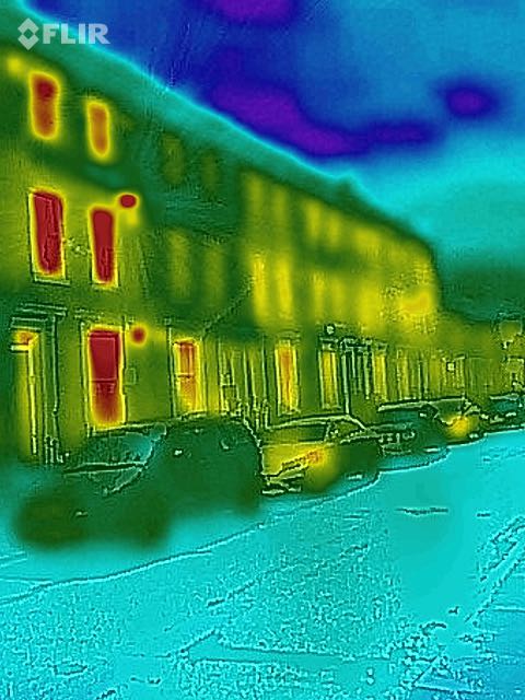 A thermal image showing the houses on my street, highlighting how windows
    leak so much heat