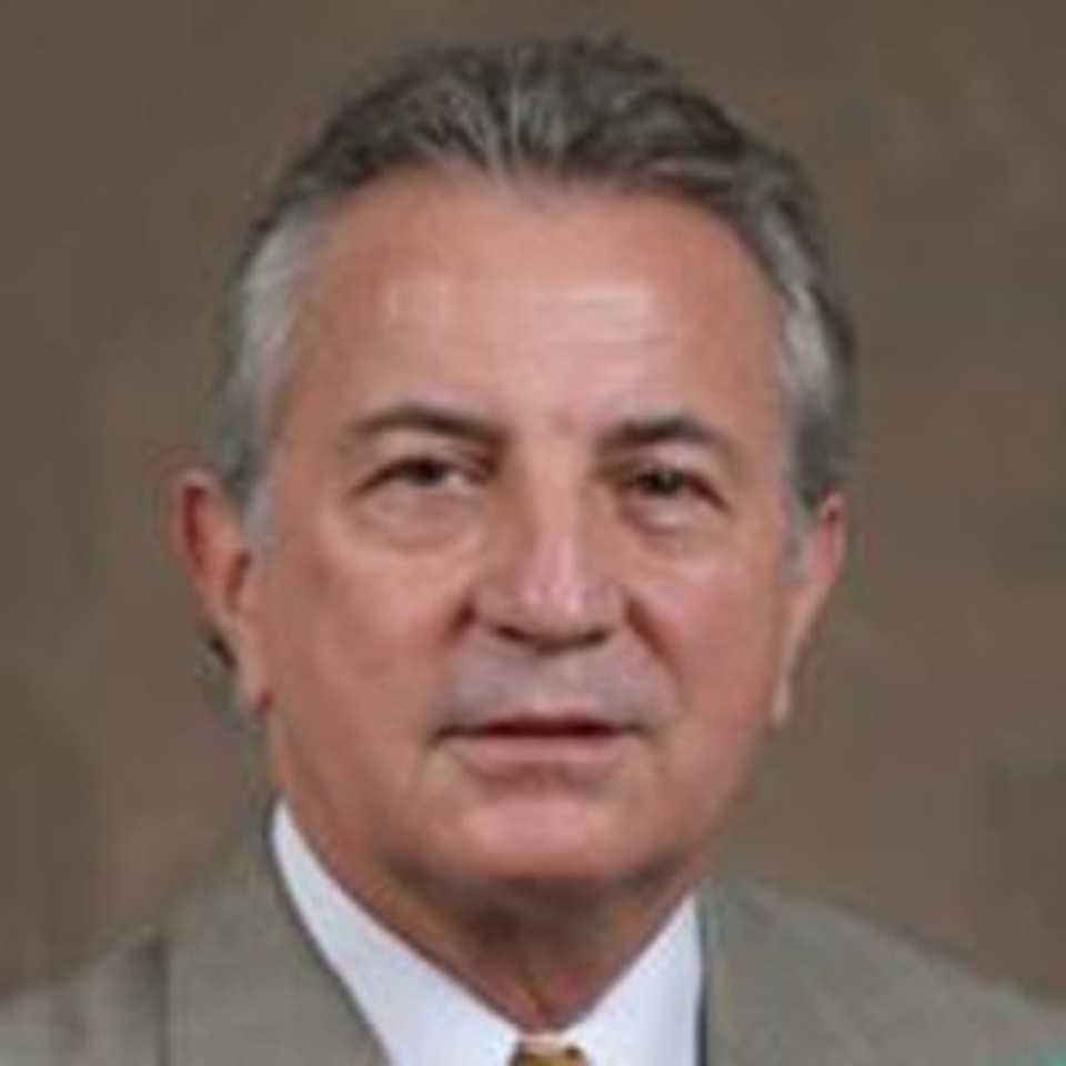Professor Charles R. Figley - smiling and wearing a brown suit