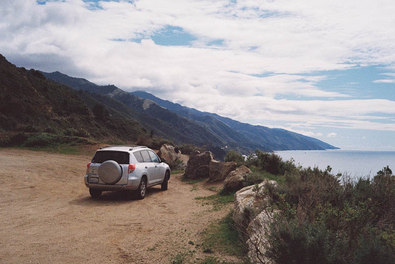 An old Toyota Rav4 pulled over beside the rocky shoreline