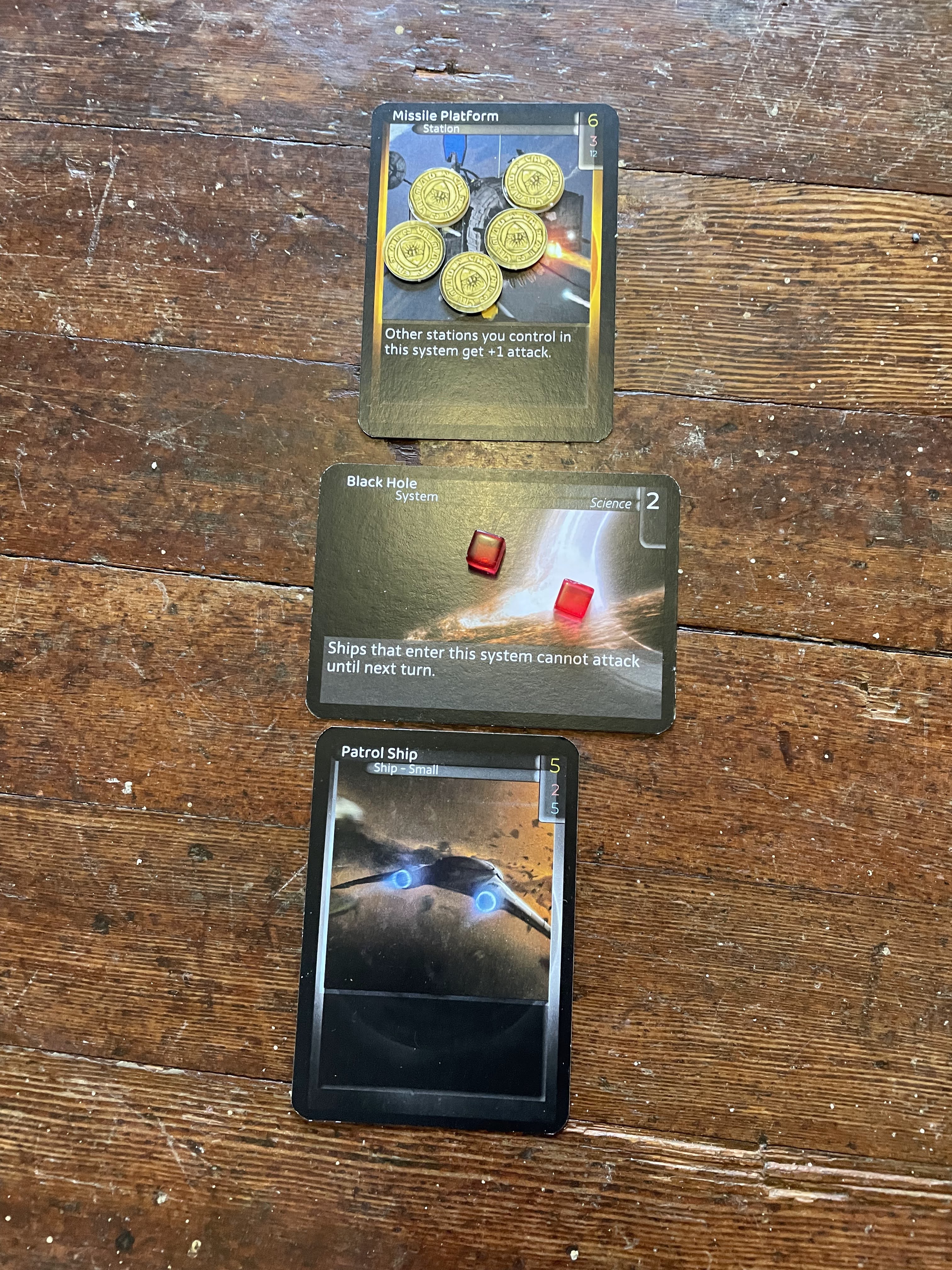 One card remains on each side of the Black Hole, with damage counters placed on the top one.