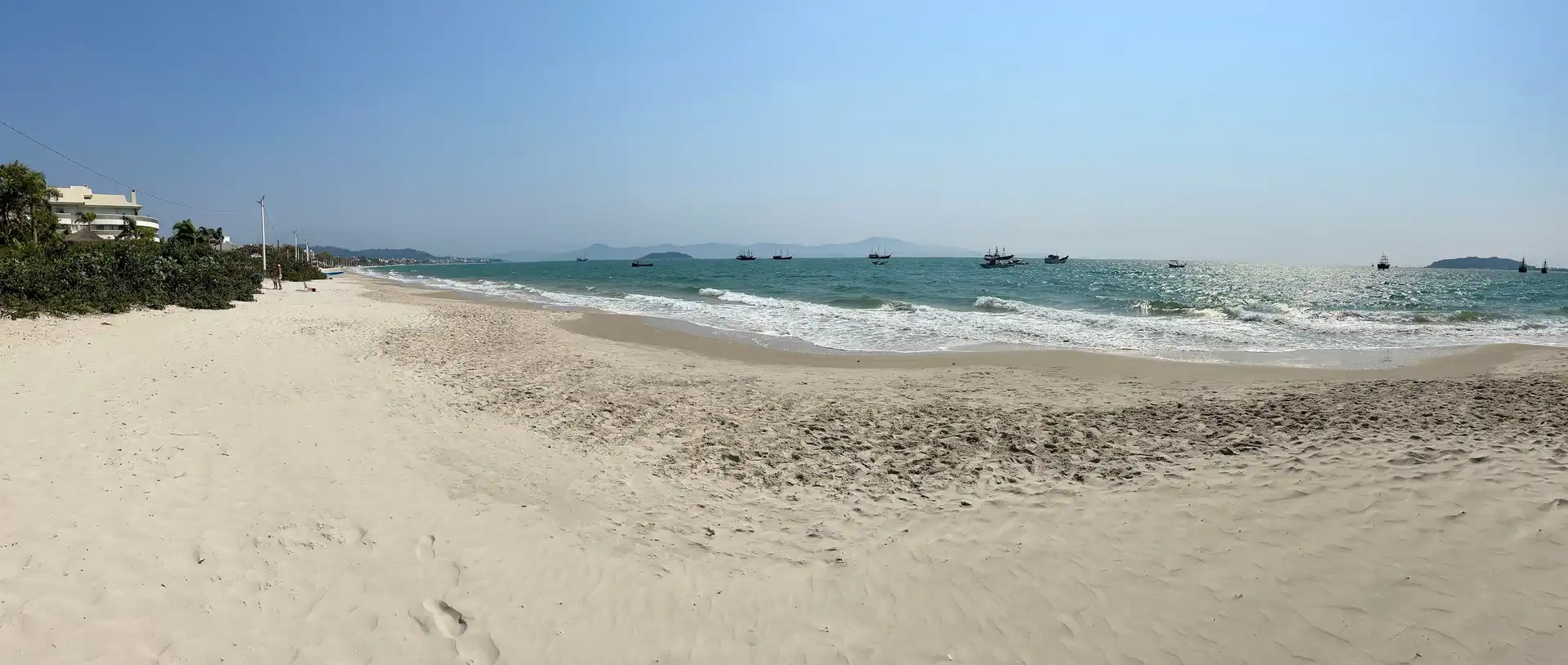 Vista da areia da praia com mar ao fundo