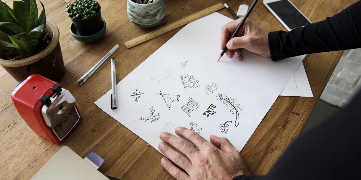 A UI designer sketching some icons A UI designer's hands sketching some user interface icons