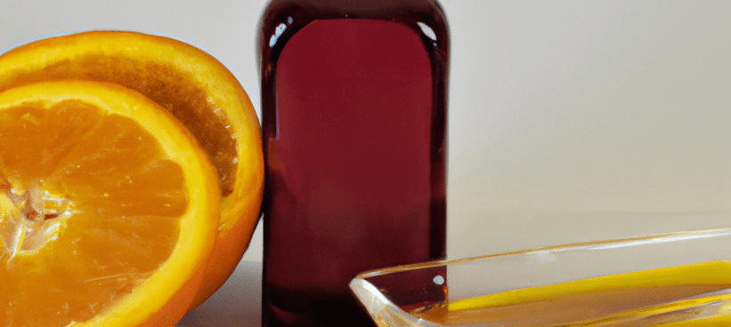 Orange près d'une fiole d'huile essentielle