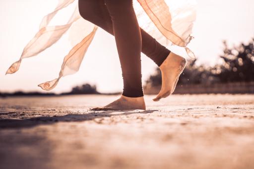 Girl running in the sand in beautiful sunlight