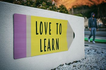 Love to learn written on a milestone rock