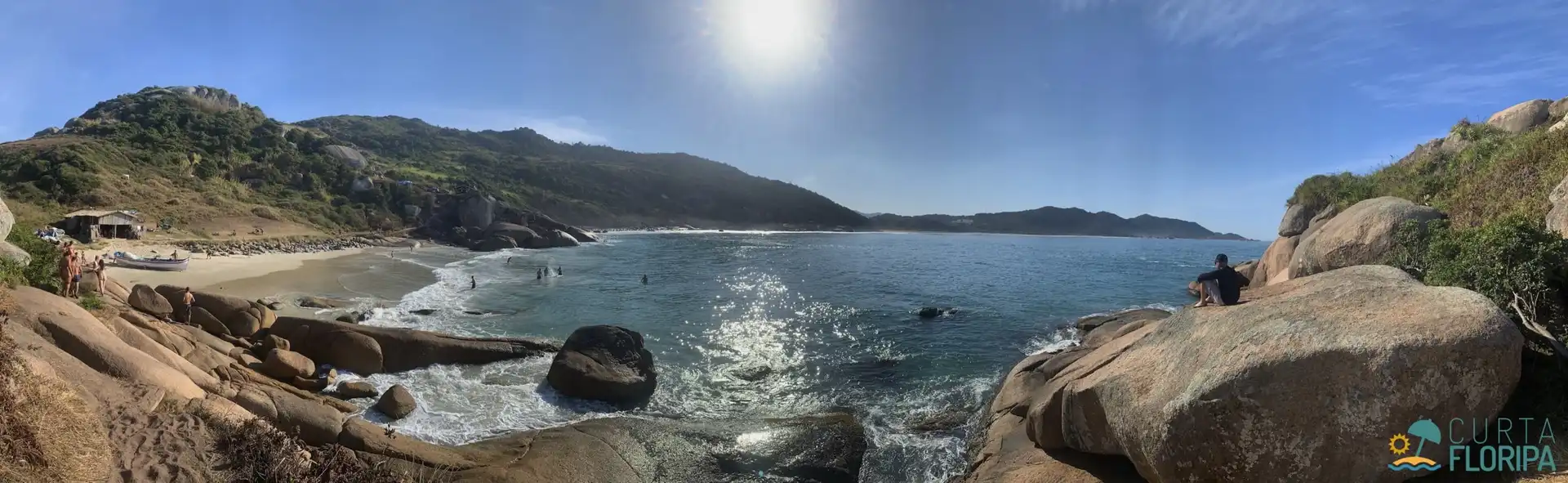 Vista panoramica da pequena praia do gravatá feita de cima das pedras características do local ao fundo o céu azul com o sol brilhante