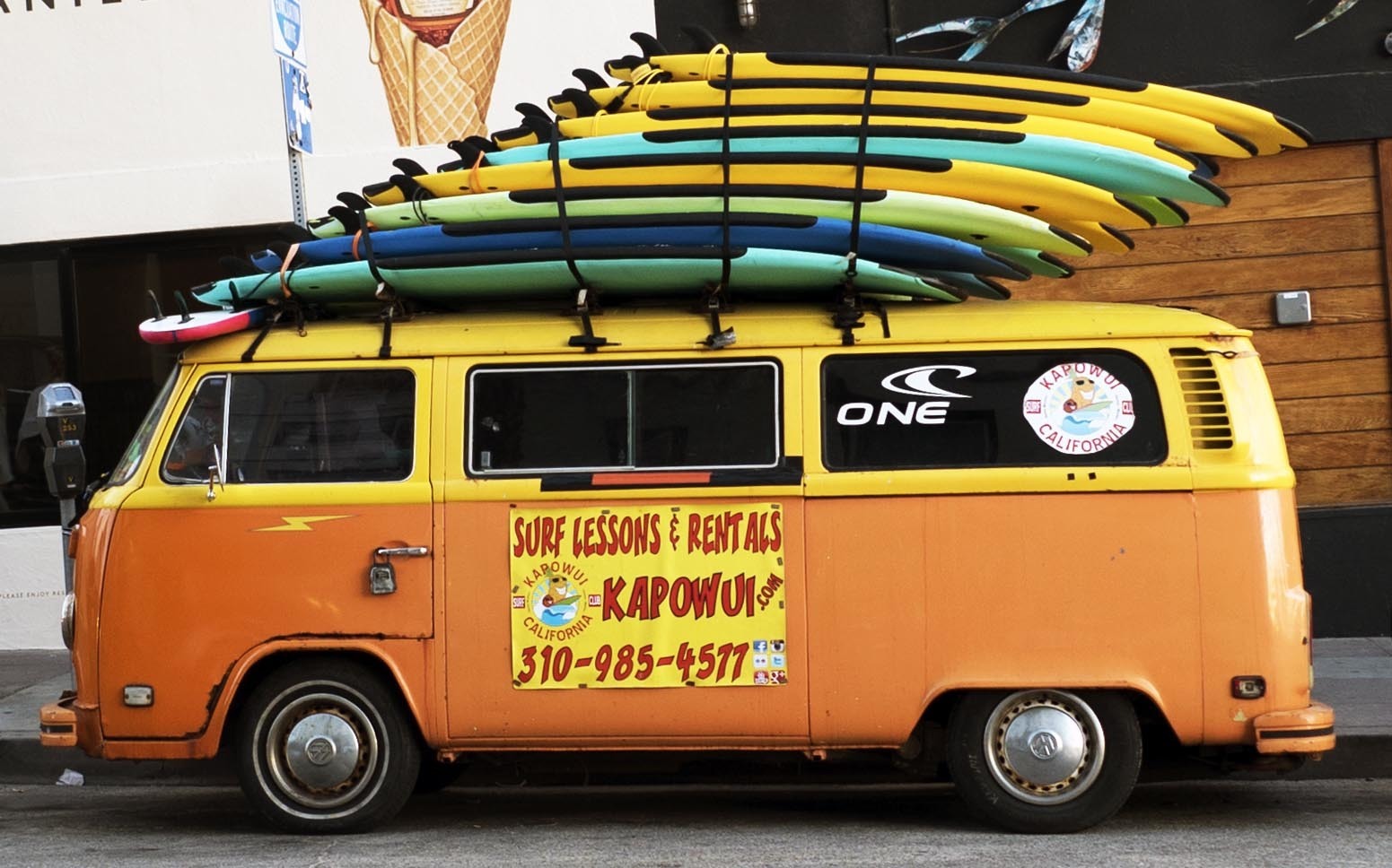 orange VW van with surfboard on top