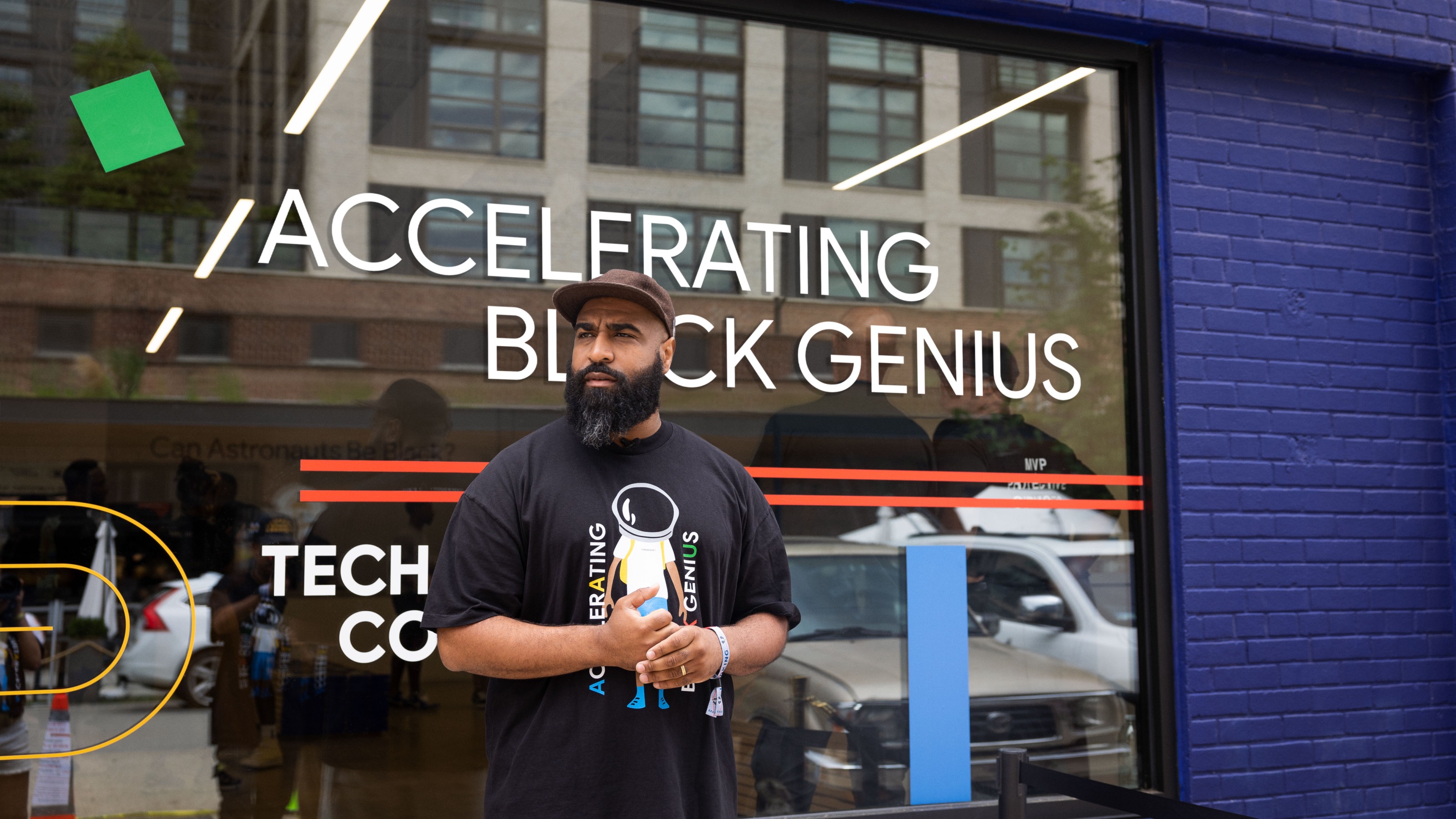 man in front of window that says “Accelerating Black Genuis”