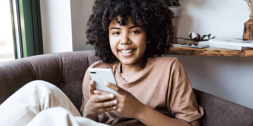 A UX designer scrolling through her phone A UX designer sitting on a sofa, scrolling through her phone