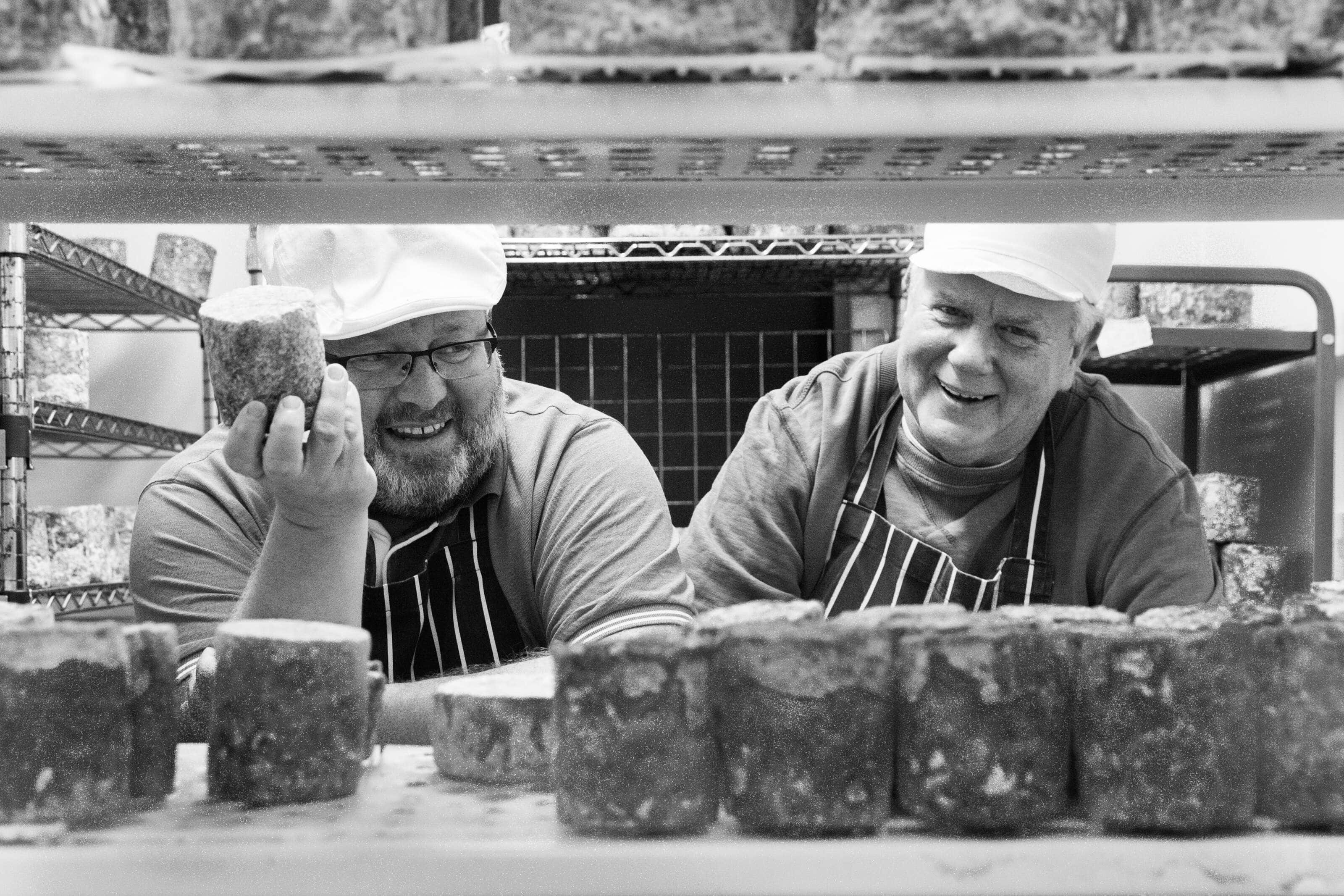 Philip and Keith, owners of Wildes Cheese of Tottenhams owners stood in one of the fridges holding Cheese and laughing.