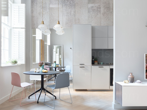Simple kitchen with white modern cupboards and small pastel grey table with one pastel grey and one pastel pink chairs  Microsoft Teams background