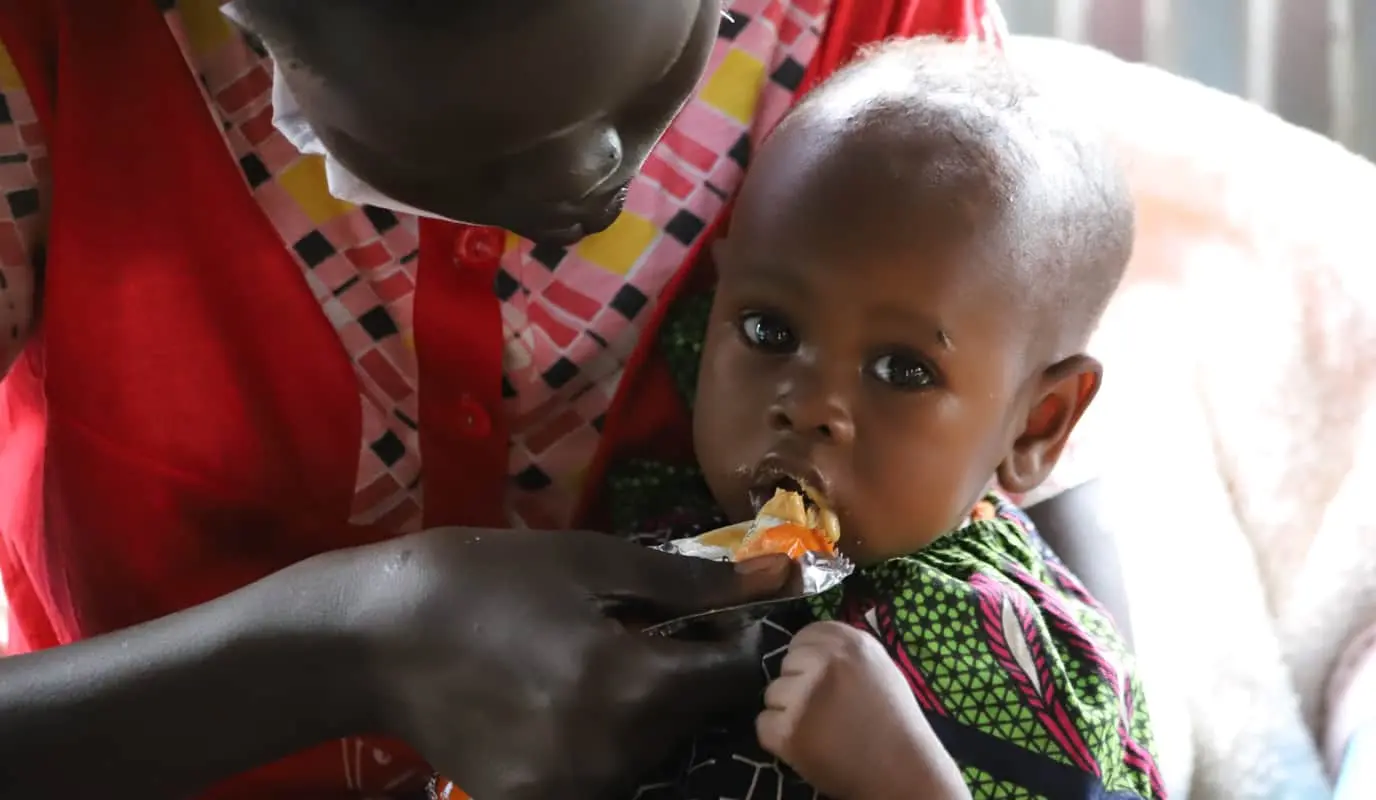 Nyalada is eating PlumpyNut, a food supplement given to malnourished children. Juba, South Sudan