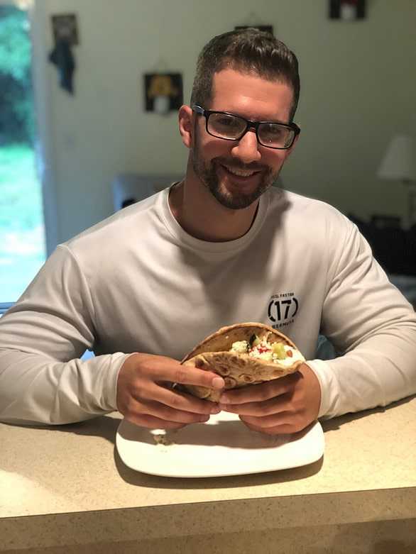 Frank eating the finished Greek Taco