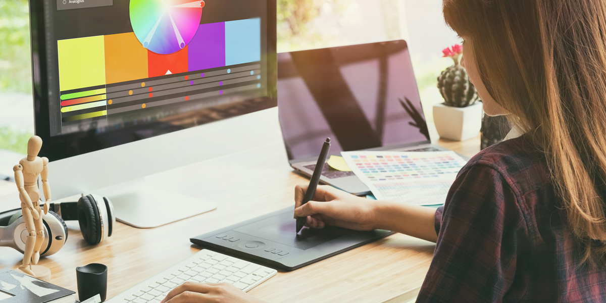 A UI designer using Adobe Color tool on an iMac A designer picking colors using Adobe Color tool on her computer