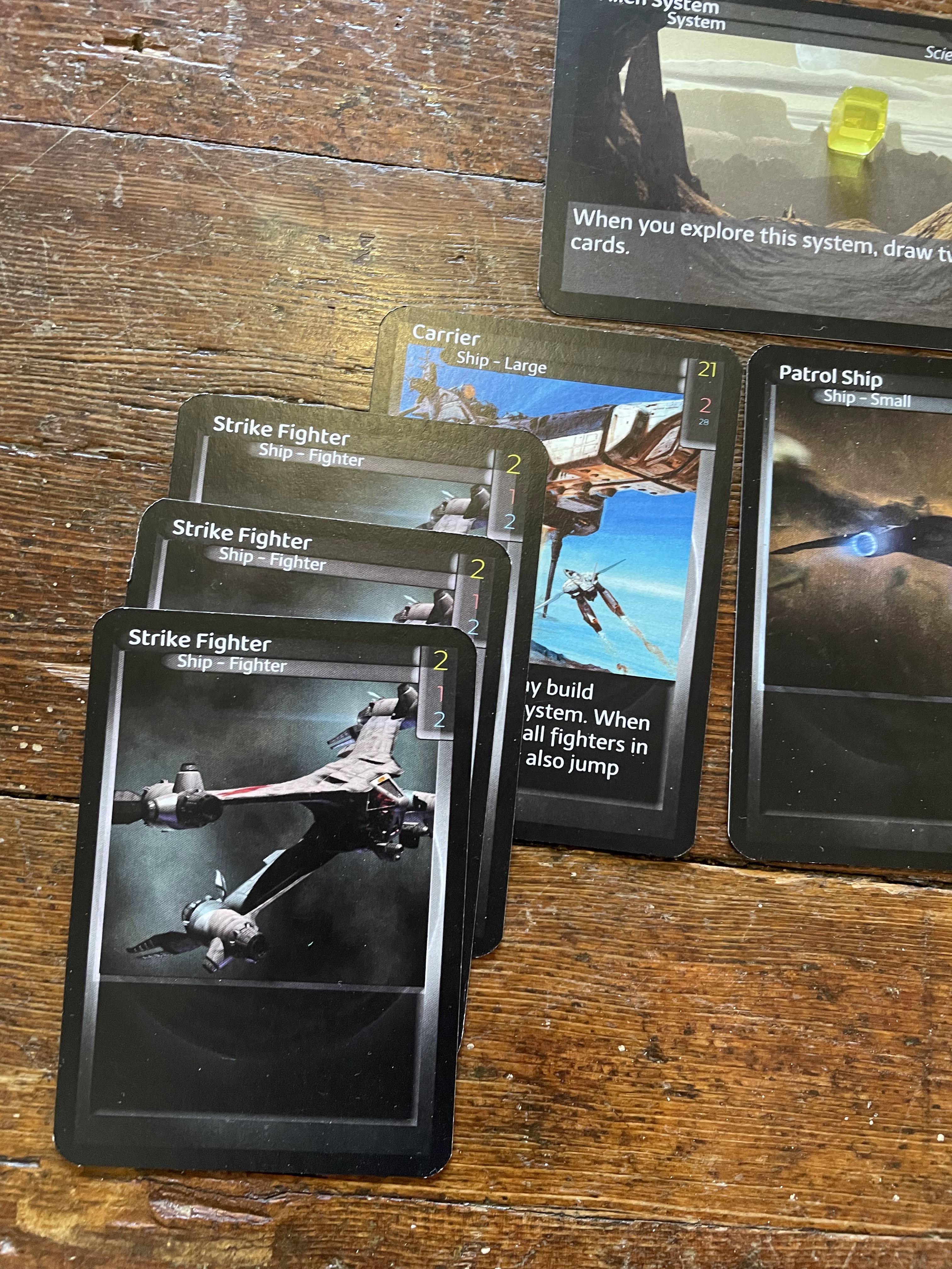 Three fighter cards are now stacked on top of the Carrier.