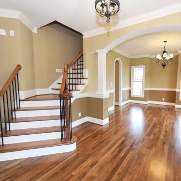 staircase leading into a finished entryway with hardwood floors