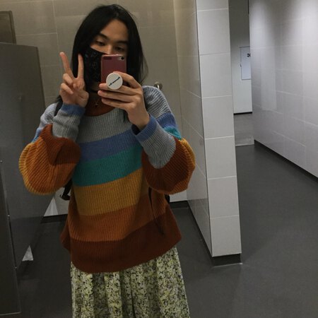 Ching Chang in a striped sweater and a floral skirt