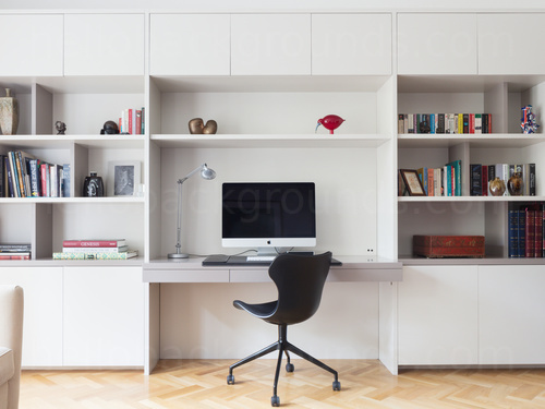 Minimalist style private office containing spacious white shelving and desk with computer behind modern design black chair Google Meet background