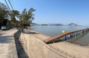 Vista panorâmica do calçadão da Tapera com trapiche ai centro e mar ao fundo