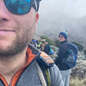 Dan Furze, close up, reflection in blue sunglass, on a hike.