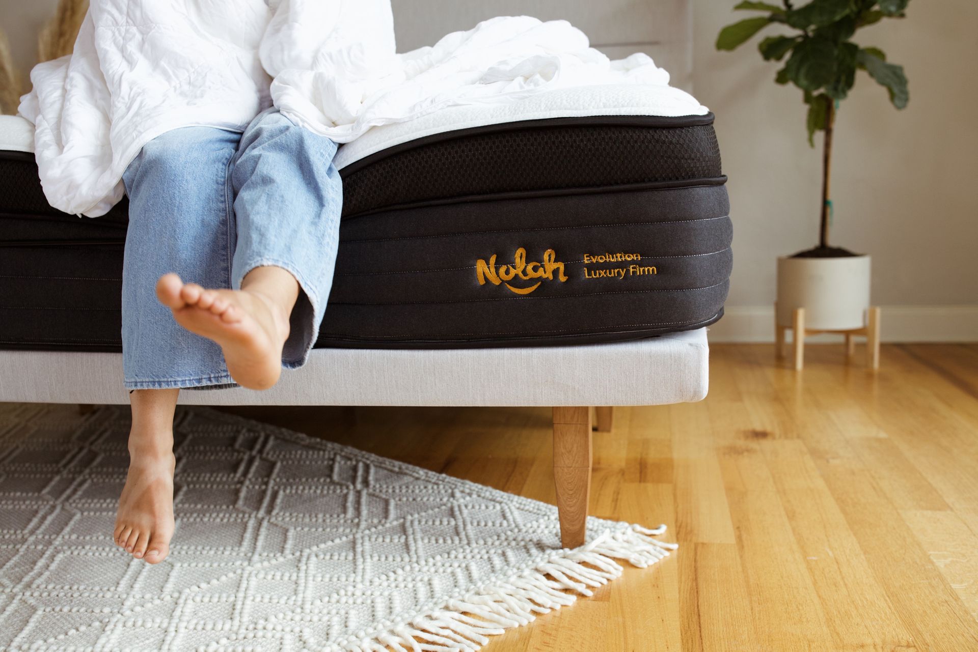 woman sitting on nolah evolution 15 hybrid mattress
