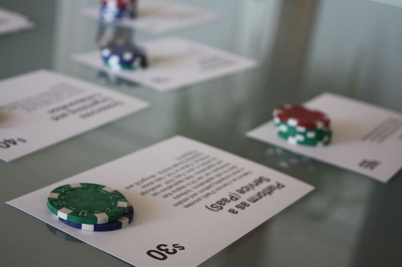 Index cards representing potential offerings of the Civic Cloud rest on a table, with each card having a stack of poker chips on top of it