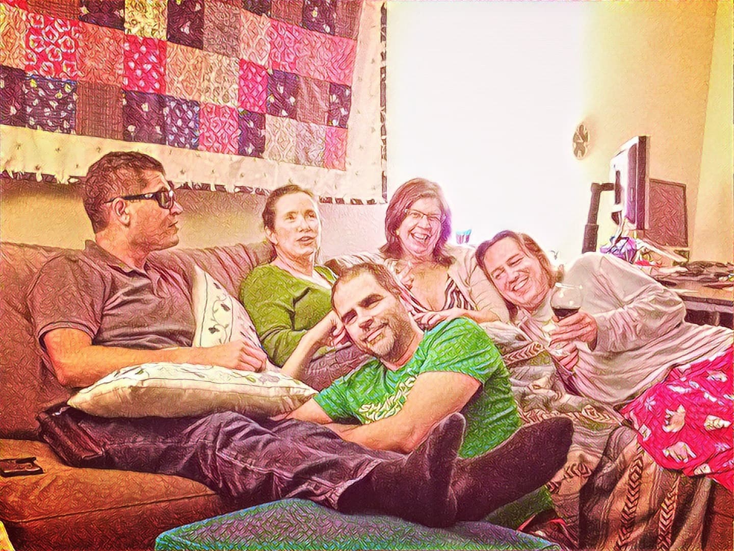 Five friends on a couch, enjoying a bottle of wine.