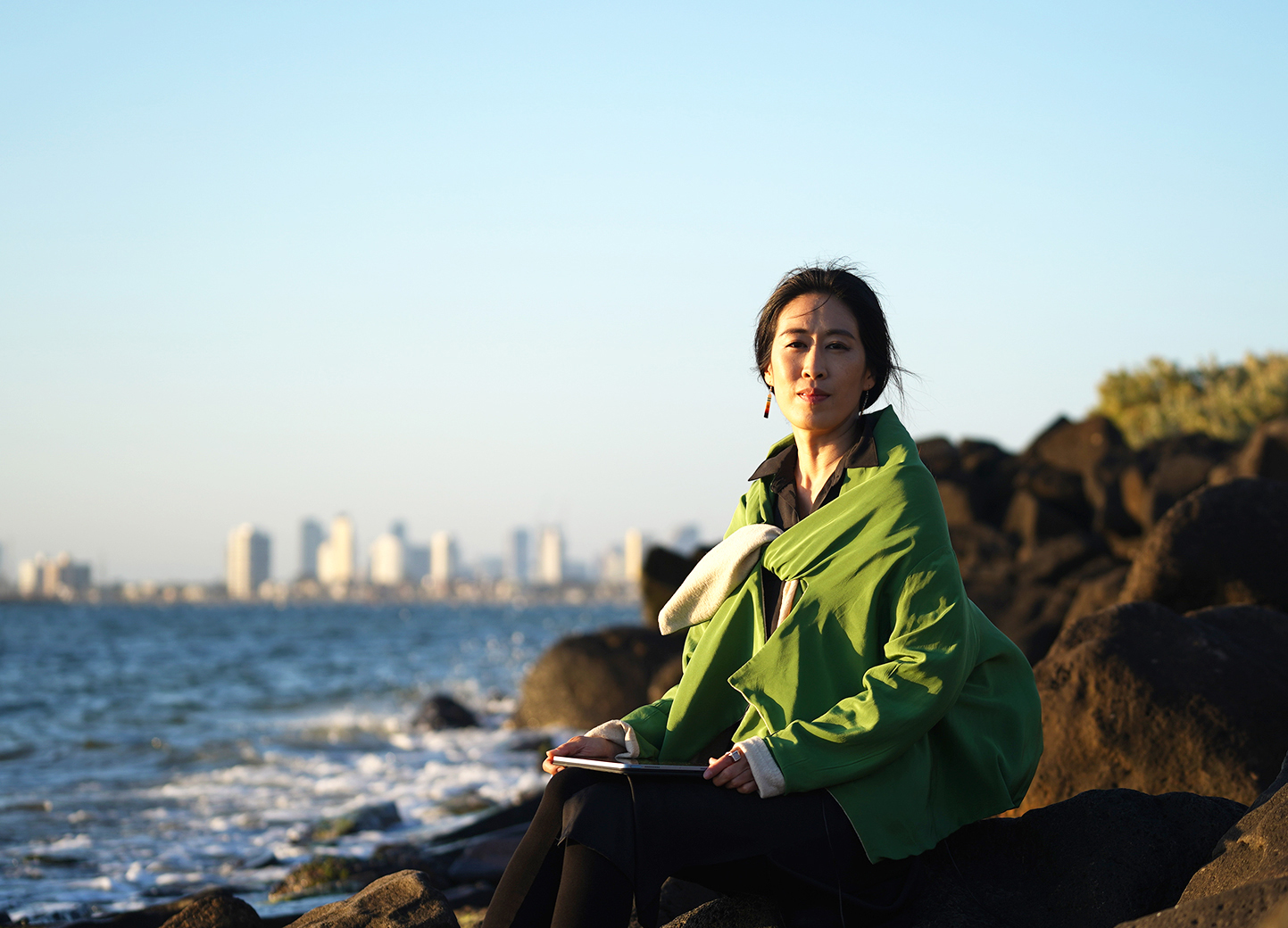 Portrait of Sunny Kim on the rocks in Sydney on a sunny late afternoon with the ocean and city in the background