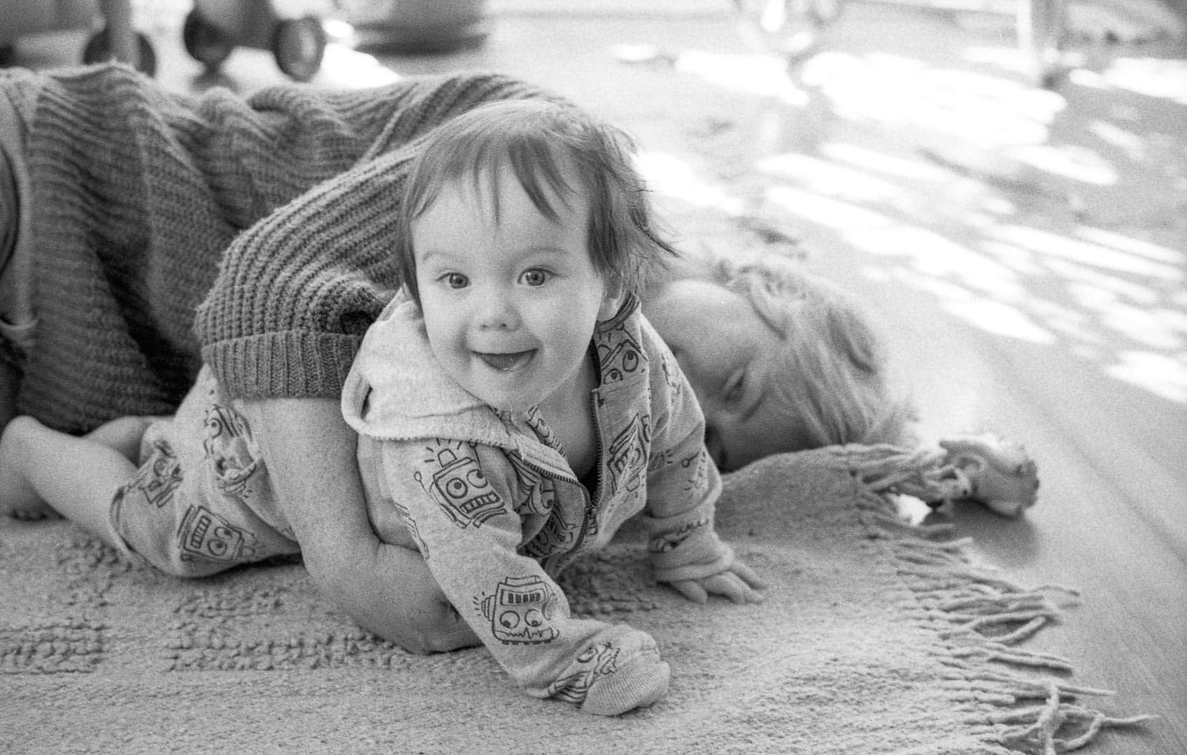 A woman and child playing on a living room floor