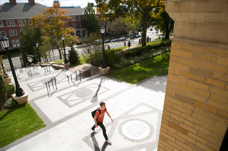 Student walking into a building on the campus of Tufts University